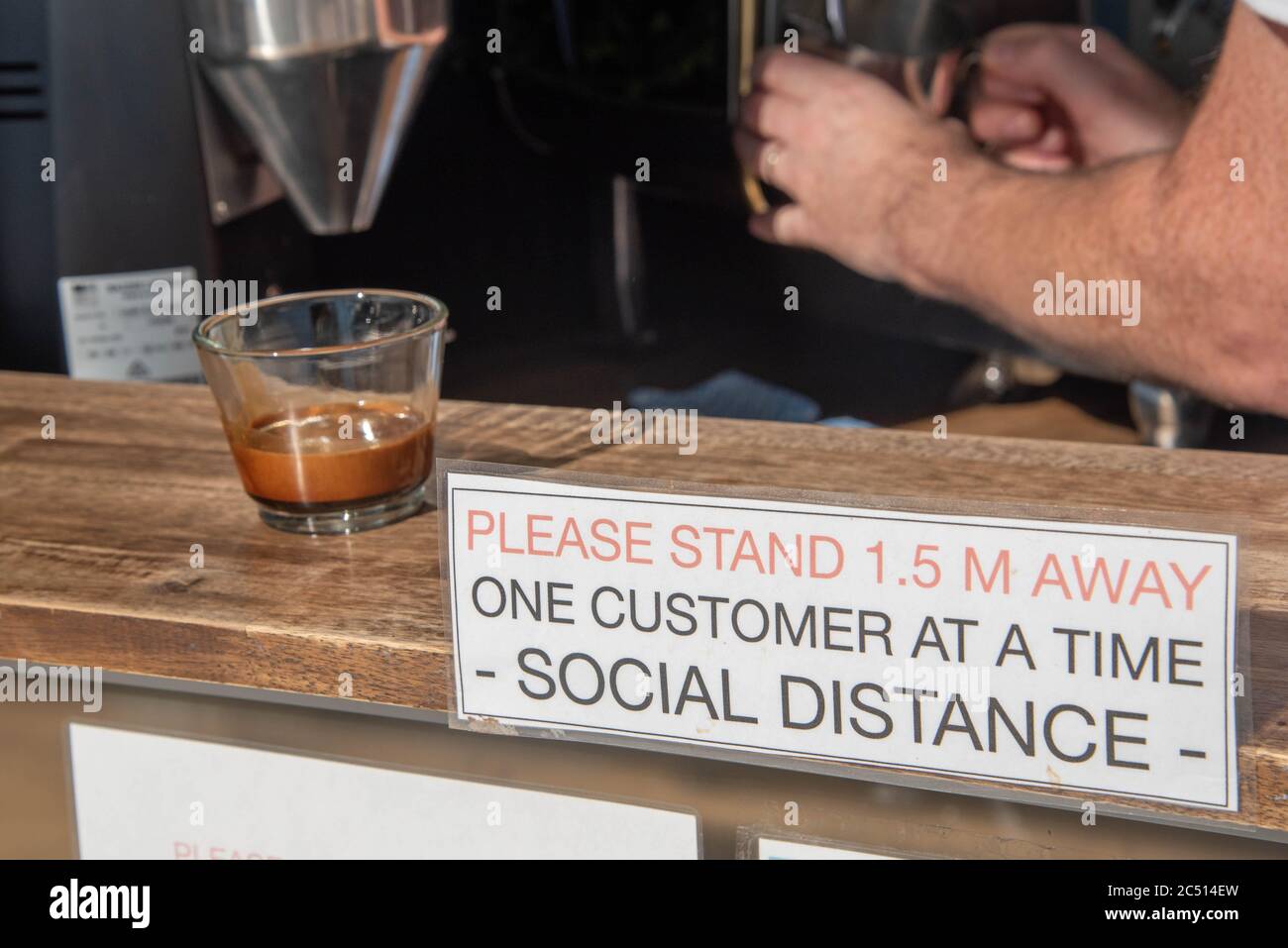 Brisbane, Australie. 30 juin 2020. Un barista sert un café près d'un panneau pour vous informer sur les distances sociales au milieu de la crise Covid-19.le Premier ministre du Queensland, Annastacia Palaszczuk, participe à une réunion du cabinet d'un État le mardi 30 juin pour annoncer une réouverture possible de la frontière et des recommandations sanitaires. (Photo de Flo Rols/Pacific Press) crédit: Agence de presse du Pacifique/Alamy Live News Banque D'Images