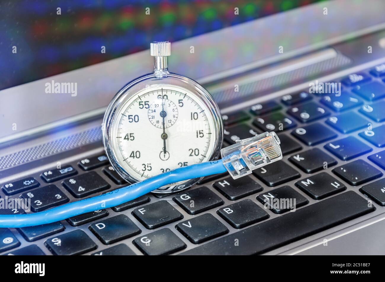 Câble et chronomètre sur le clavier de l'ordinateur symbolisant la bande passante de la connexion Internet Banque D'Images