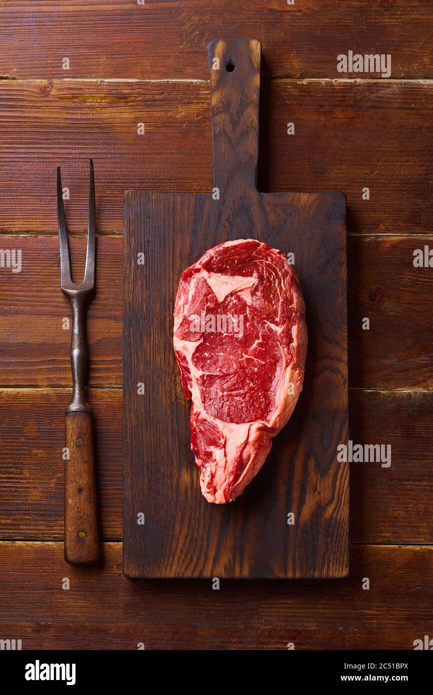 Flat Lay Black Angus prime mandrin de boeuf steak sur planche à découper fond en bois copie espace. Plat Lay ingrédient de cuisson Banque D'Images