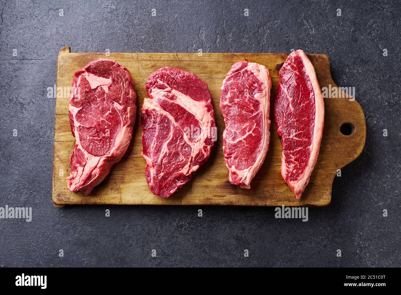 Variété de viandes fraîches de bœuf noir Angus Prime : ribeye, stripline, rouleau de mandrin et picanha sur une planche à cutiing en bois Banque D'Images