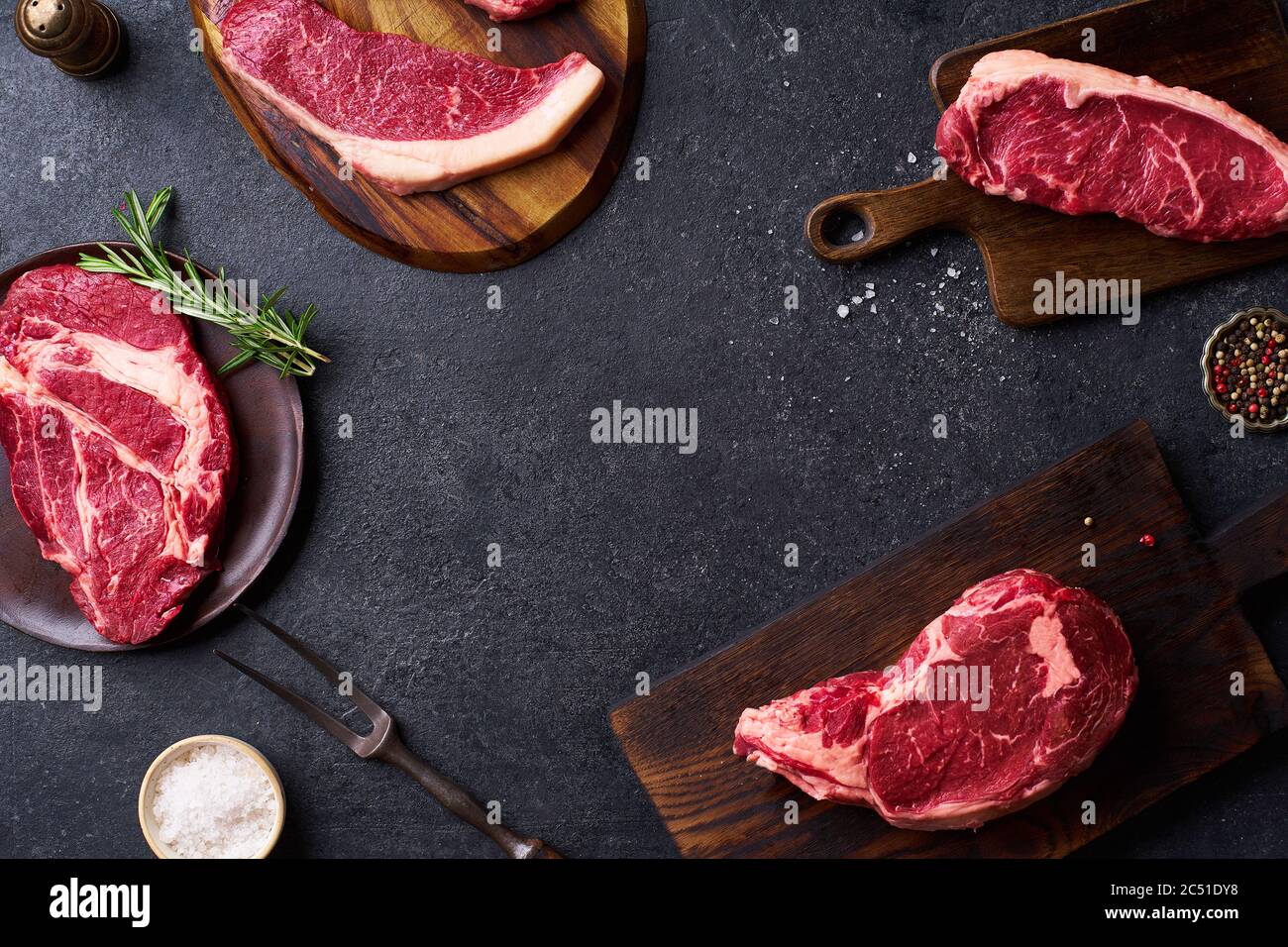 Plat variété de plats de bœuf frais Black Angus Prime : ribeye, stripline, rouleau de mandrin et picanha sur les planches à cutiing espace de copie de cadre Banque D'Images
