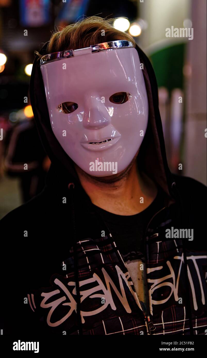 Un révélateur dans un masque blanc et un noir à capuchon sur une rue à Shibuya, Tokyo, pour célébrer Halloween Banque D'Images