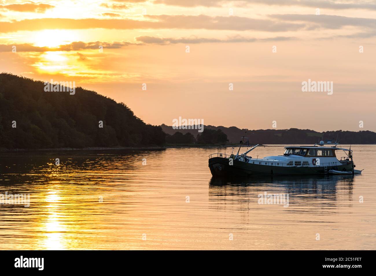 Bateau qui s'ancre juste au large de la côte de la mer Baltique pendant un beau coucher de soleil coloré Banque D'Images