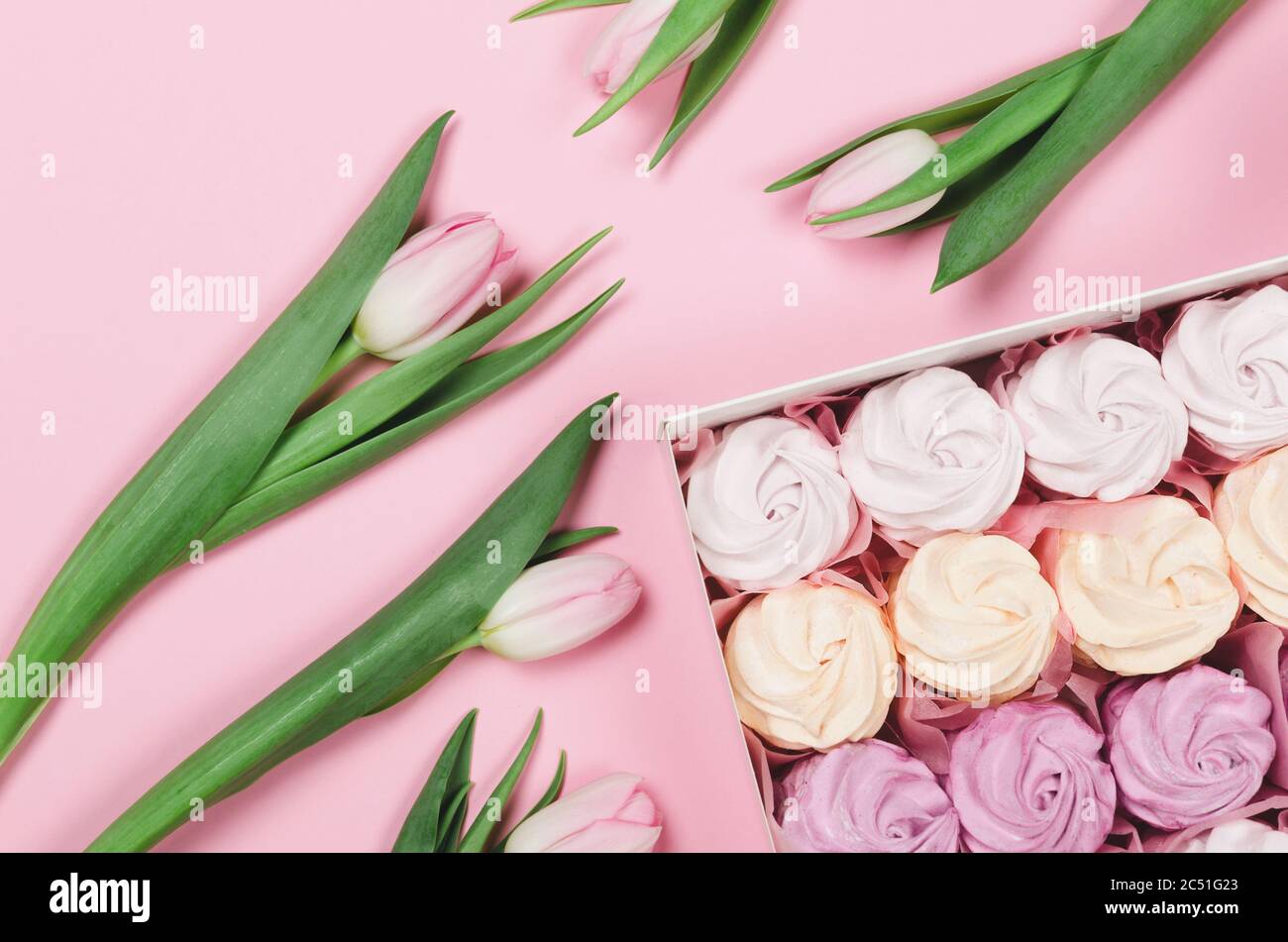 Couleur guimauve d'air dans une boîte cadeau sur fond rose avec tulipes . Cadeau de Saint-Valentin Banque D'Images