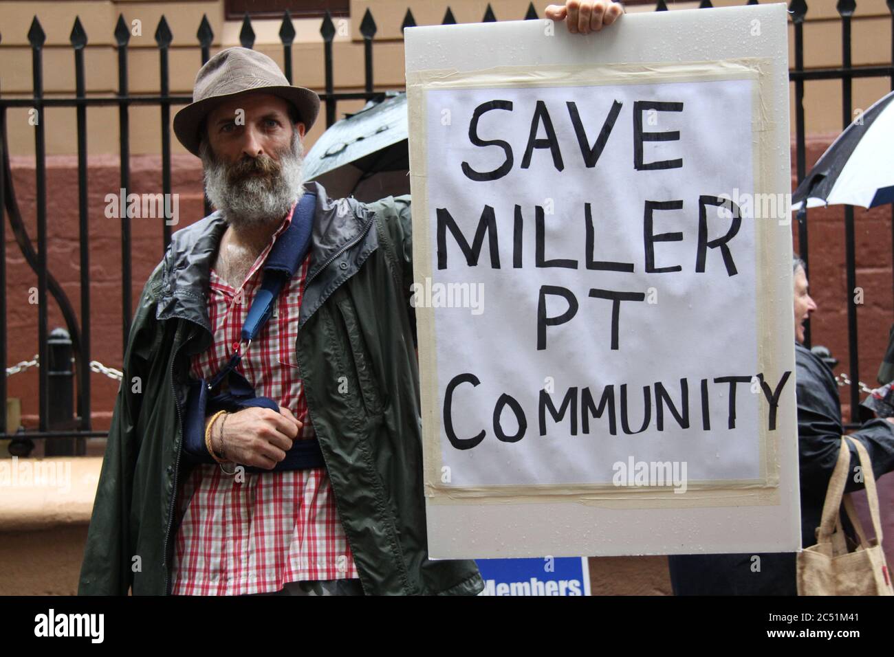 Un manifestant devant le Parlement de Nouvelle-Galles du Sud, sur la rue Macquarie, porte un panneau indiquant « Save Miller Pt Community » - une référence à un secteur de choix Banque D'Images