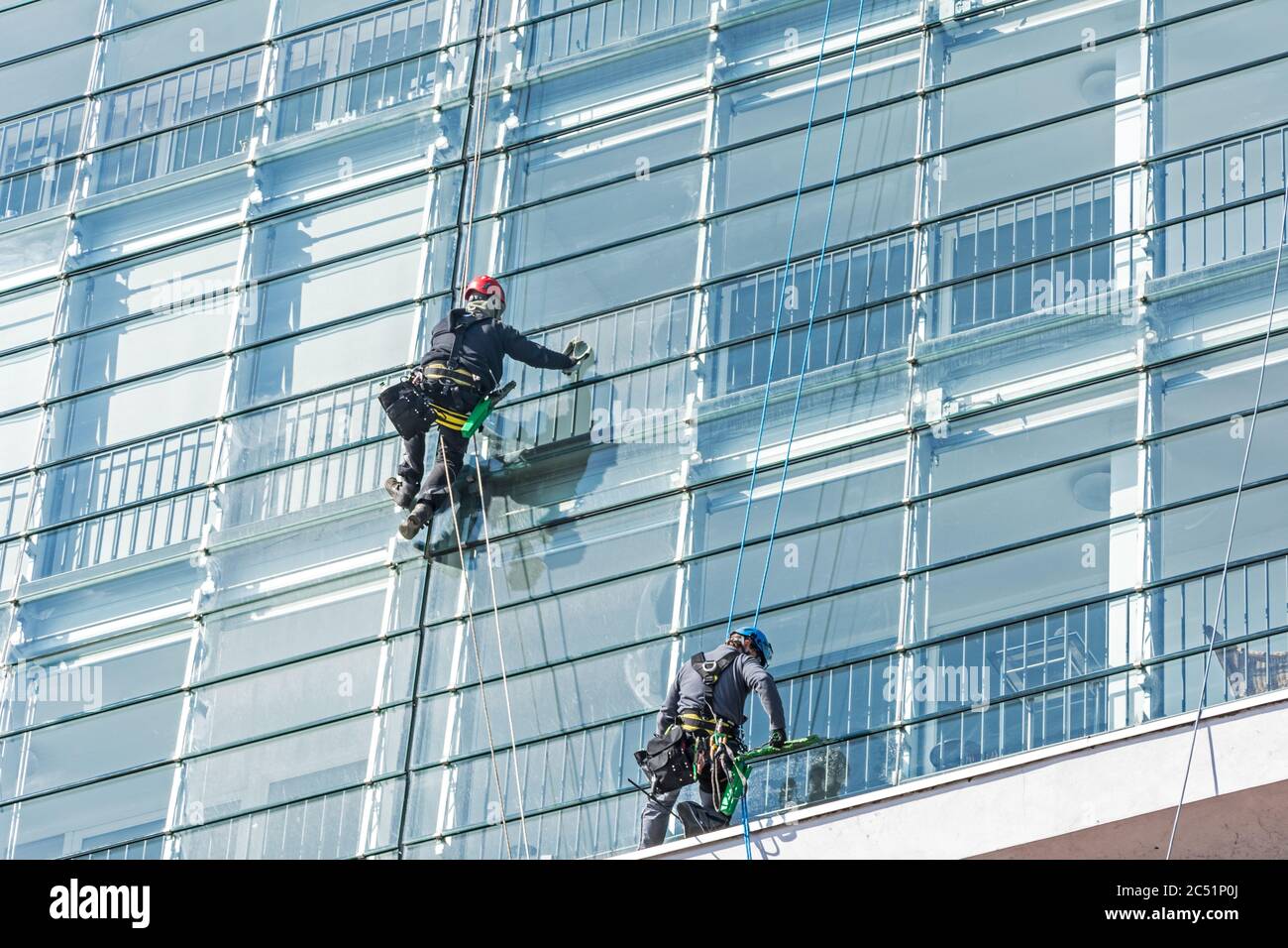 Nettoyant pour vitres sur la façade de verre d'un gratte-ciel Banque D'Images
