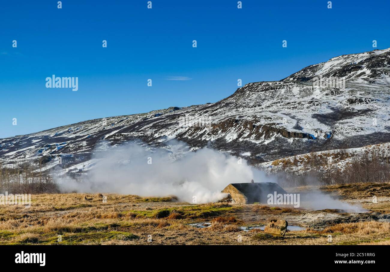 Vapeur bouillonnante provenant de sources thermales chaudes geyser dans le paysage d'hiver, cercle d'or, Islande Banque D'Images