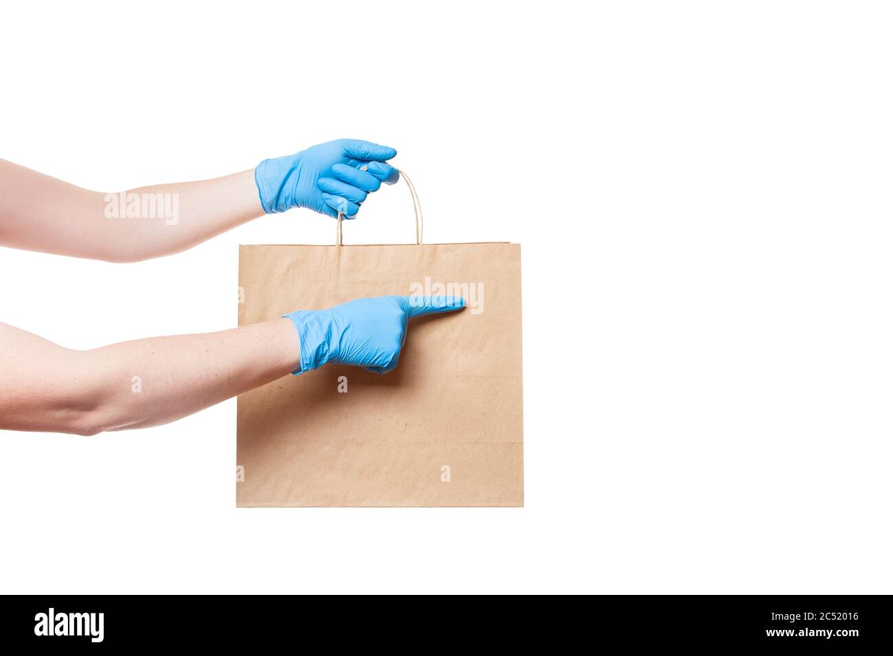 mains dans des gants stériles de messagerie pour la livraison sûre de nourriture dans l'emballage écologique de l'artisanat pointe un doigt à un endroit vide pour le logo, maquette iso Banque D'Images