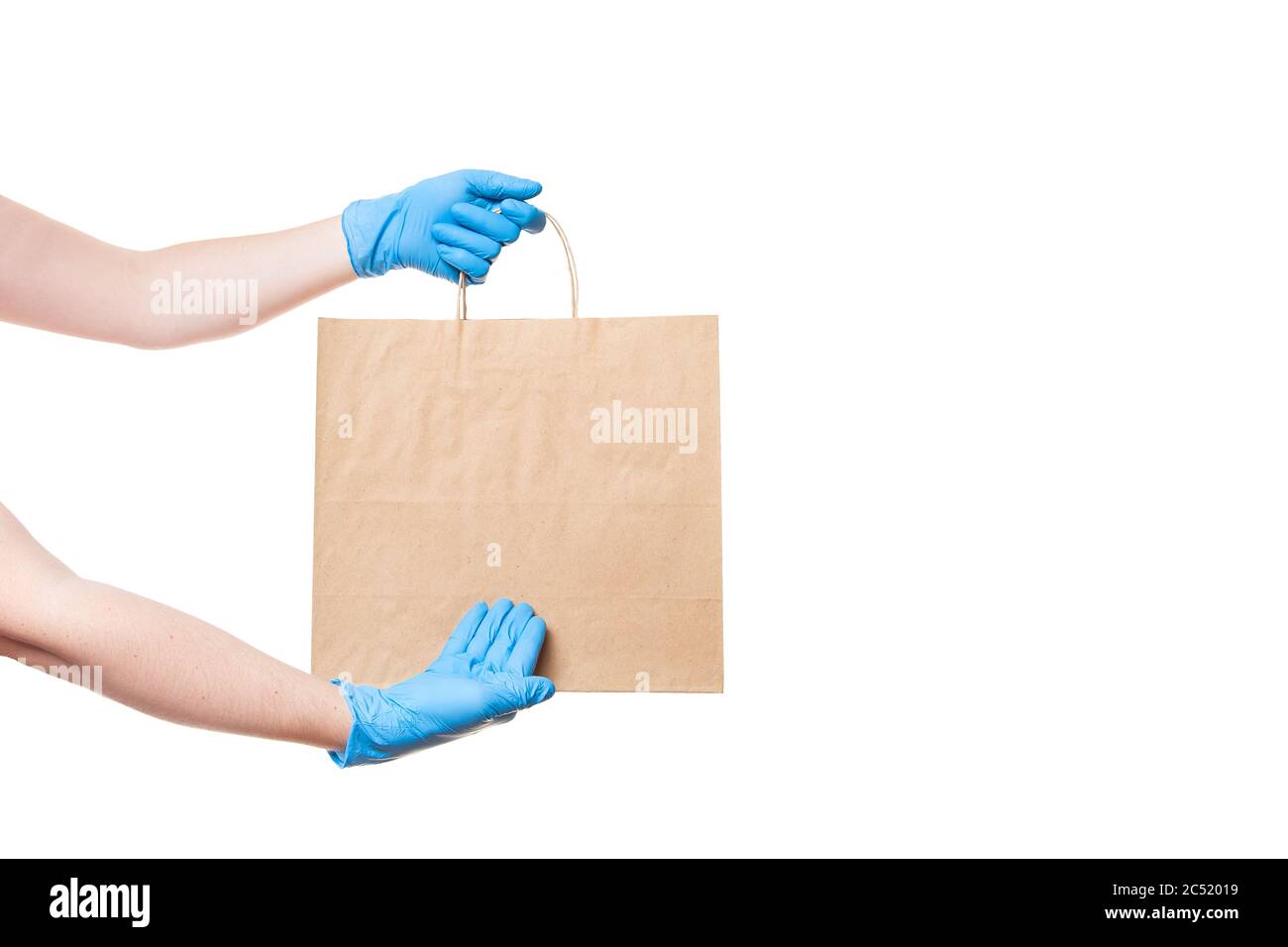 mains dans des gants stériles d'un messager pour la livraison sécuritaire de nourriture dans un point de colis de l'artisanat écologique avec une main à un endroit vide pour un logo, mock Banque D'Images