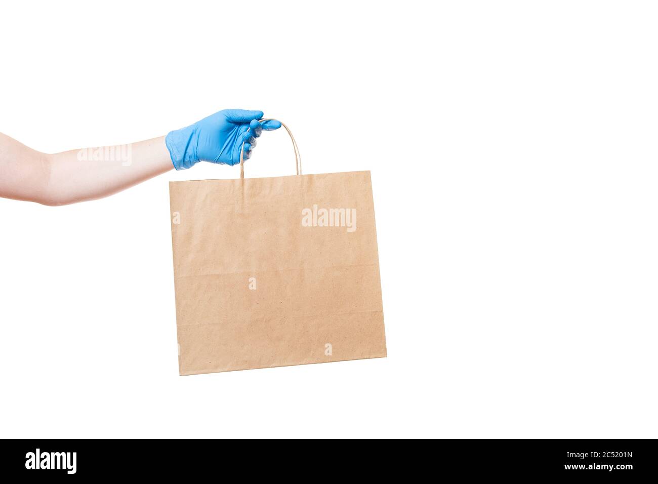 Un emballage écologique en papier marron tient la main d'un livreur dans un gant stérile isolé sur un fond blanc avec espace de copie, deliv sûr Banque D'Images