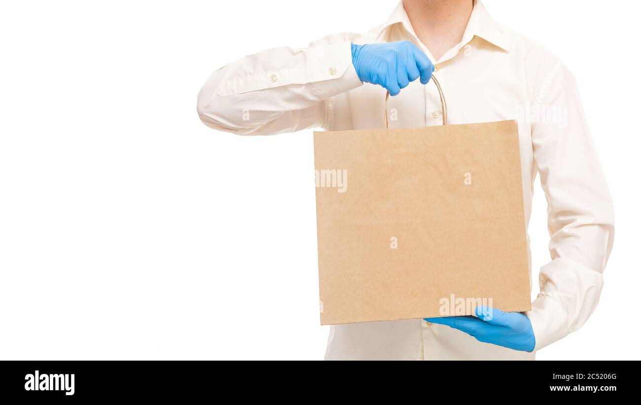 livreur mains dans des gants stériles de messagerie pour la livraison sûre de nourriture dans un emballage écologique de l'artisanat label onu pendant la quarantaine de la pandémie social dist Banque D'Images