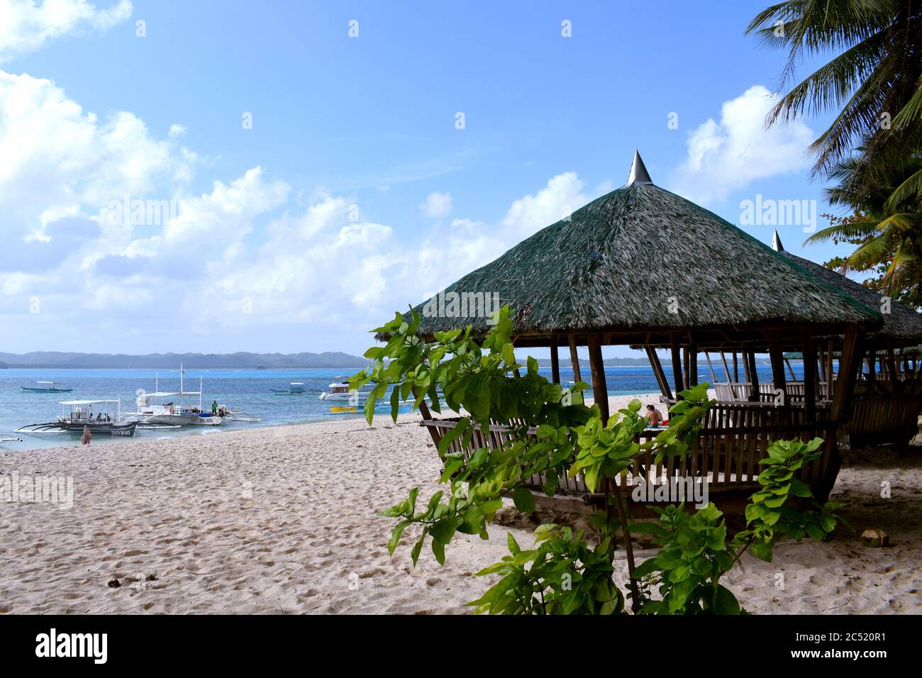 Saison d'été aux Philippines sur une belle île de sable blanc avec des bateaux, cococotier et nipa huts. Île Siargao Philippines Banque D'Images