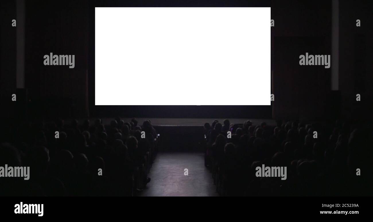 Spectateurs dans une salle de cinéma sombre avec écran vierge Banque D'Images