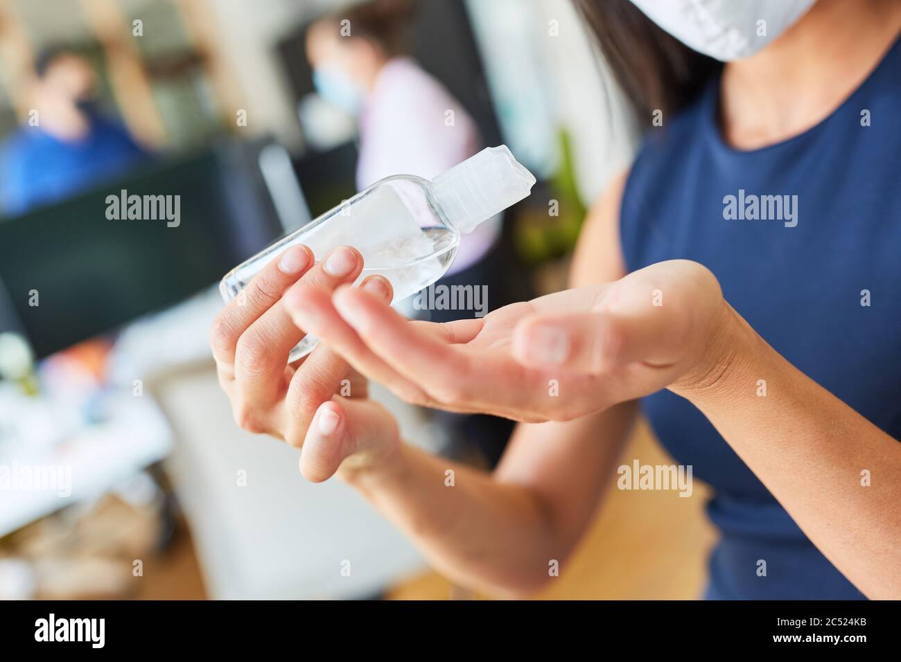 Femme d'affaires utilisant un désinfectant pour les mains pour désinfecter les mains à cause du virus Covid-19 et du corona Banque D'Images