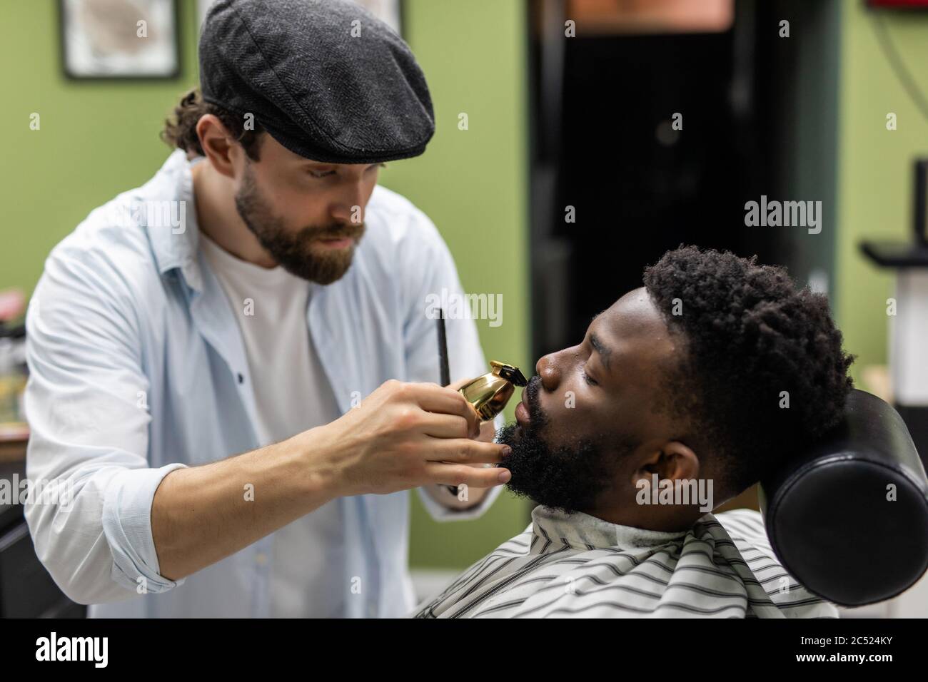 Coiffeur tondeuse cheveux sur jeune homme noir non rasé en atelier de  barbershop.coiffeur professionnel coupe cheveux avec machine à haver  électrique sur l'Afrique Photo Stock - Alamy