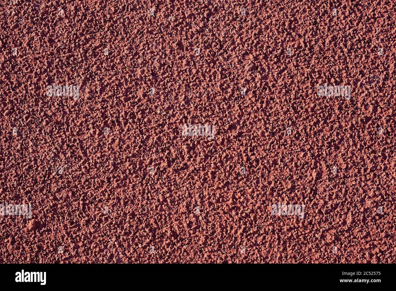 Vue macro de la surface de l'arène sportive rouge rugueuse Banque D'Images