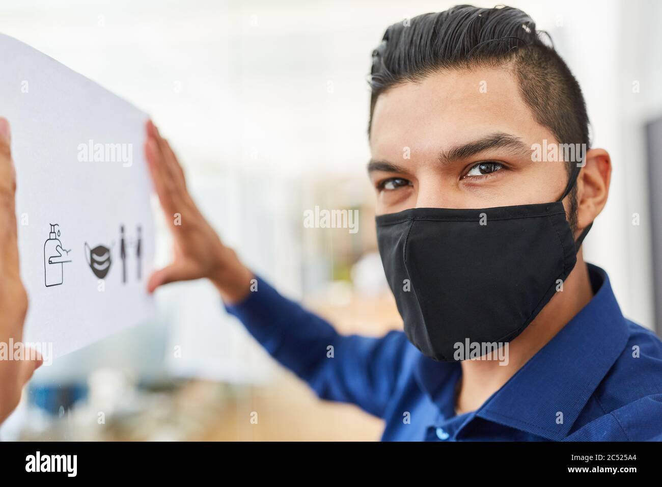 Homme d'affaires avec masque de visage fixe les règles d'hygiène comme prévention contre le coronavirus et Covid-19 Banque D'Images