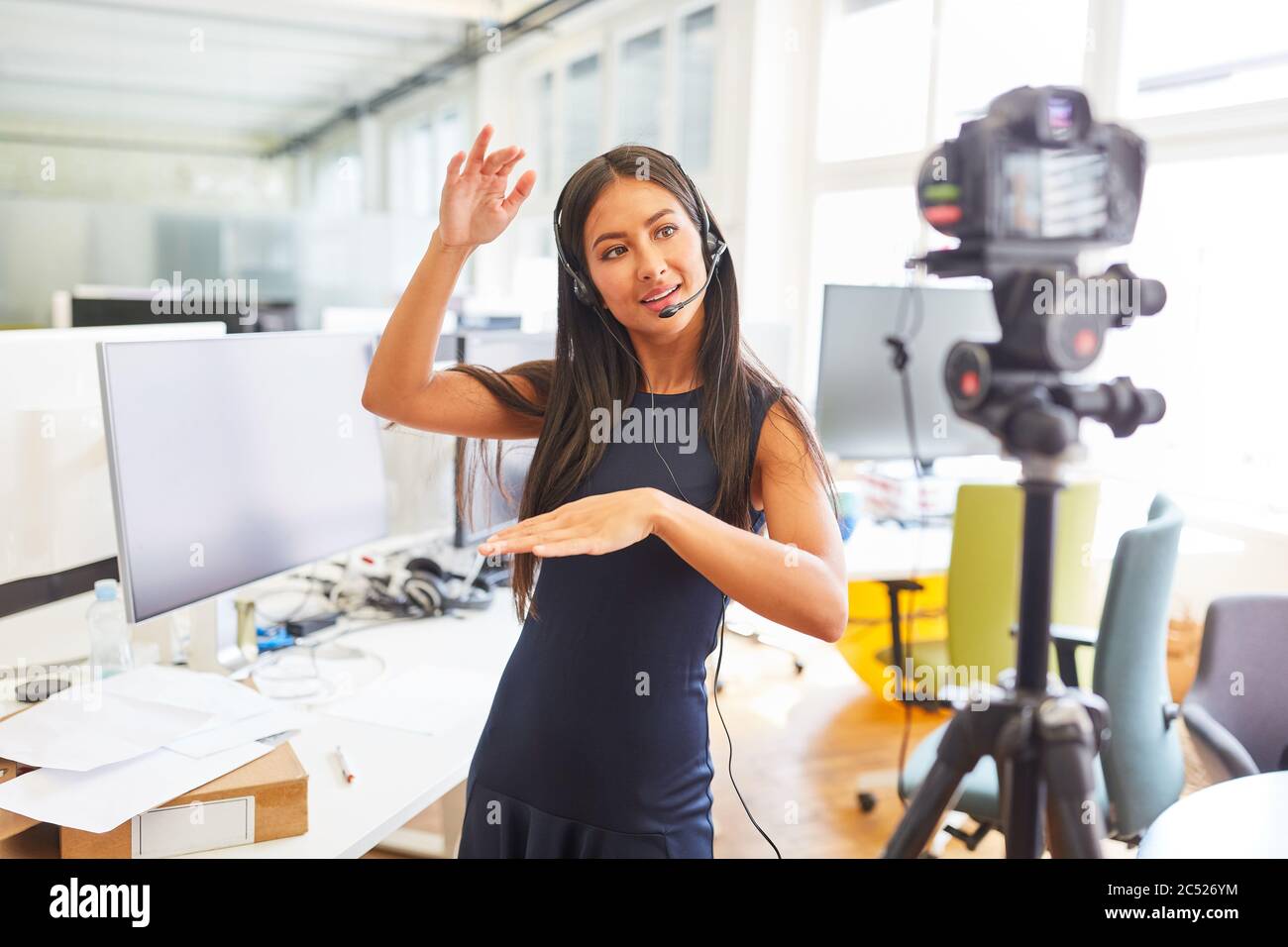 Femme d'affaires avec casque d'enregistrement vidéo pour un tutoriel en ligne en streaming sur Internet Banque D'Images