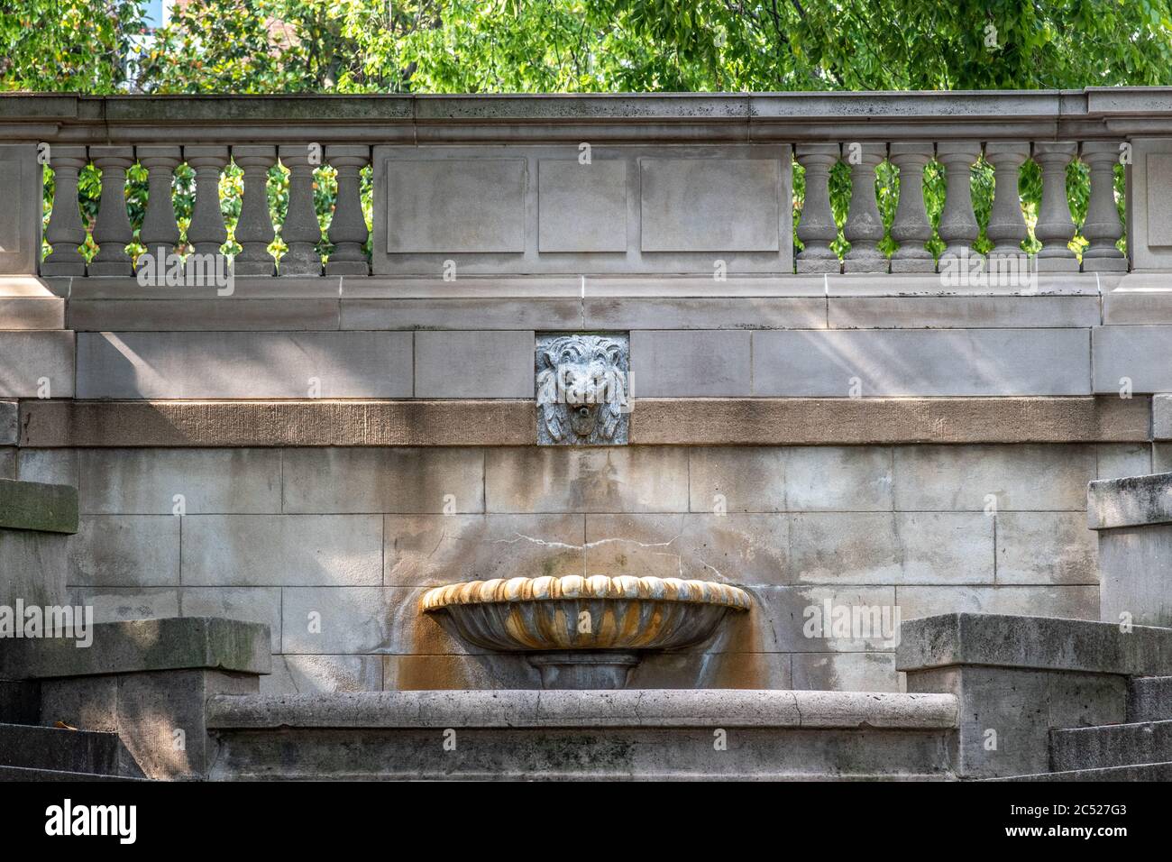 Fontaine de Lion en pierre près de l'entrée d'un beau parc. Colonnes de pierre en arrière-plan. Banque D'Images