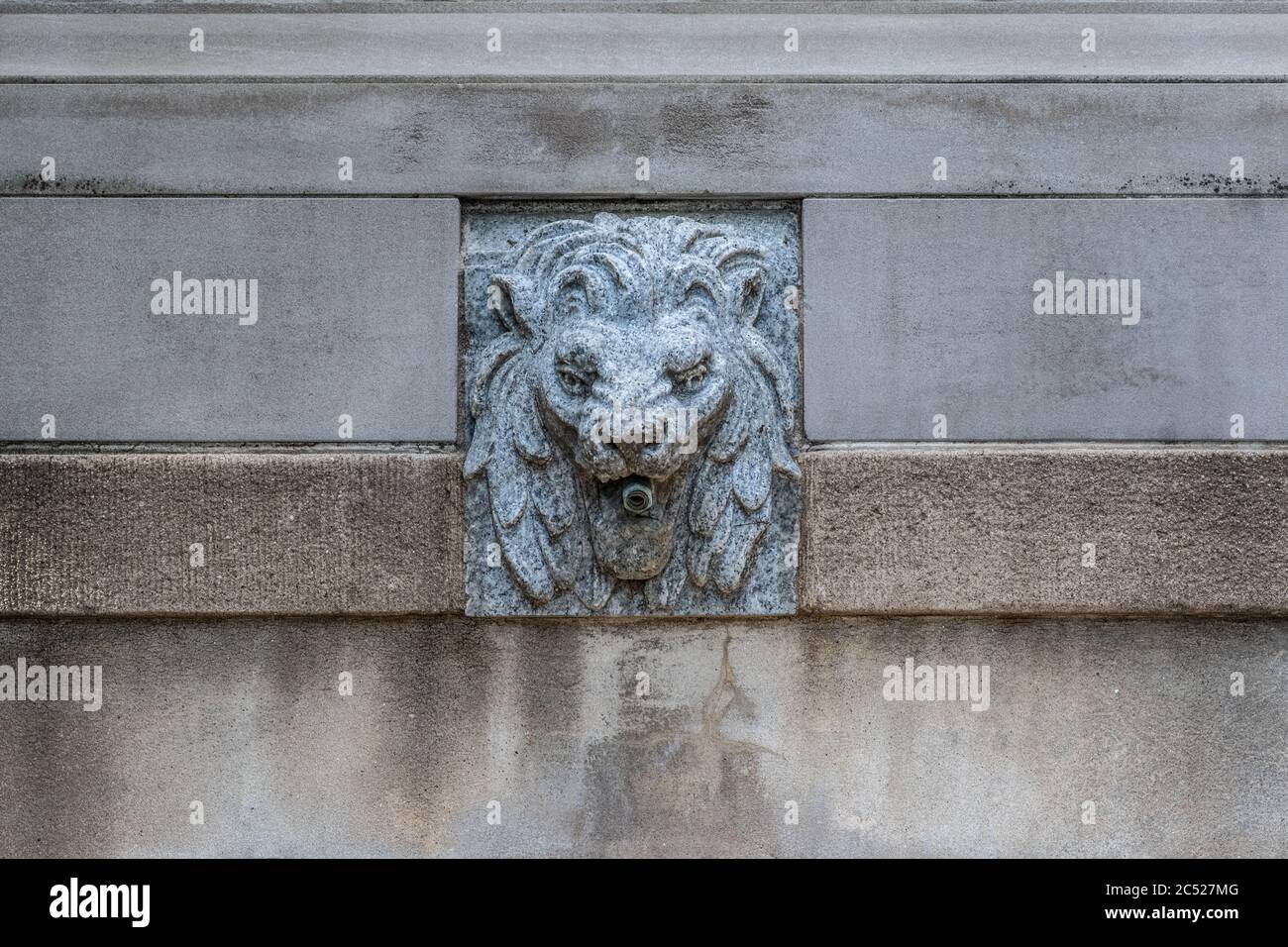 Fontaine de Lion en pierre près de l'entrée d'un beau parc. Colonnes de pierre en arrière-plan. Banque D'Images