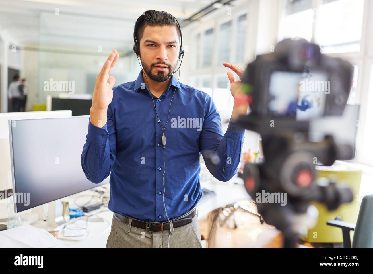 Homme d'affaires comme un entraîneur enregistrant une vidéo d'enseignement pour un tutoriel Internet en streaming Banque D'Images