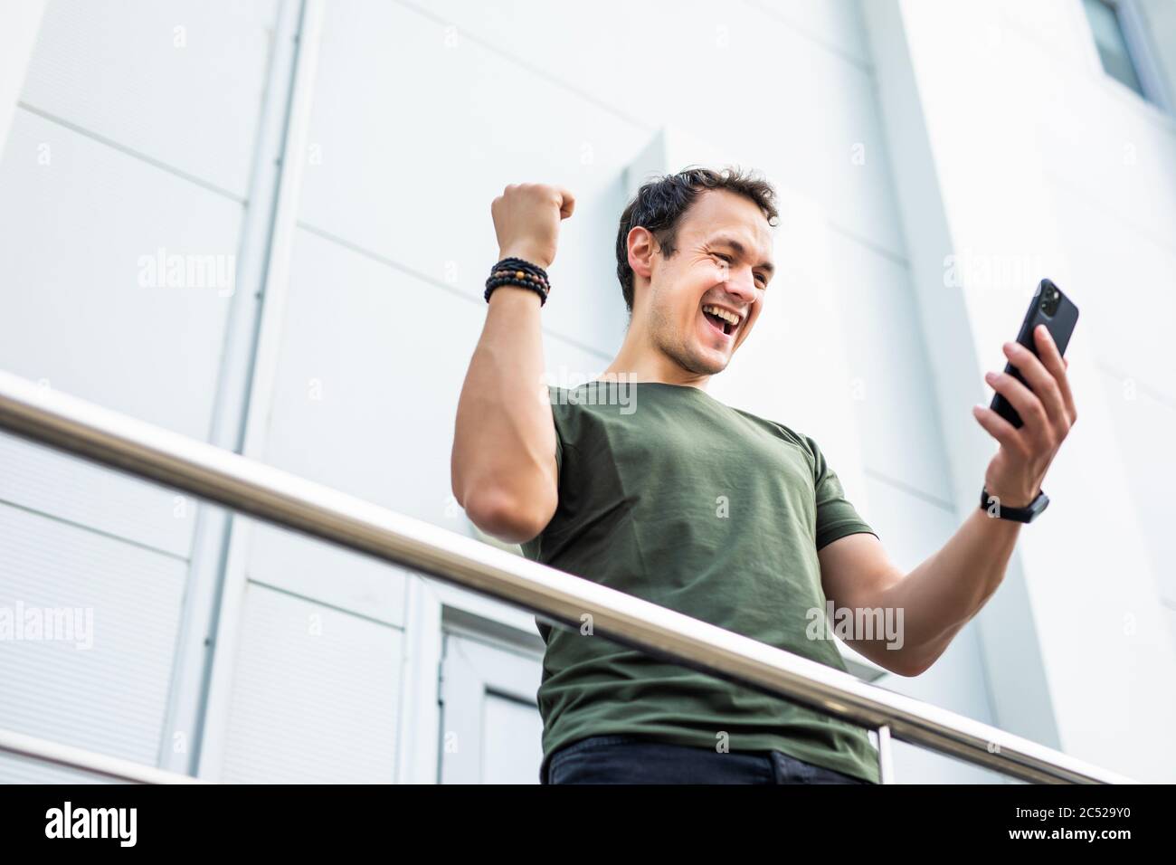 Surpris homme tenant le téléphone regardant le téléphone choqué par les nouvelles inattendues des médias sociaux. Un jeune homme étonné, stupéfié par le contenu en ligne mobile Banque D'Images