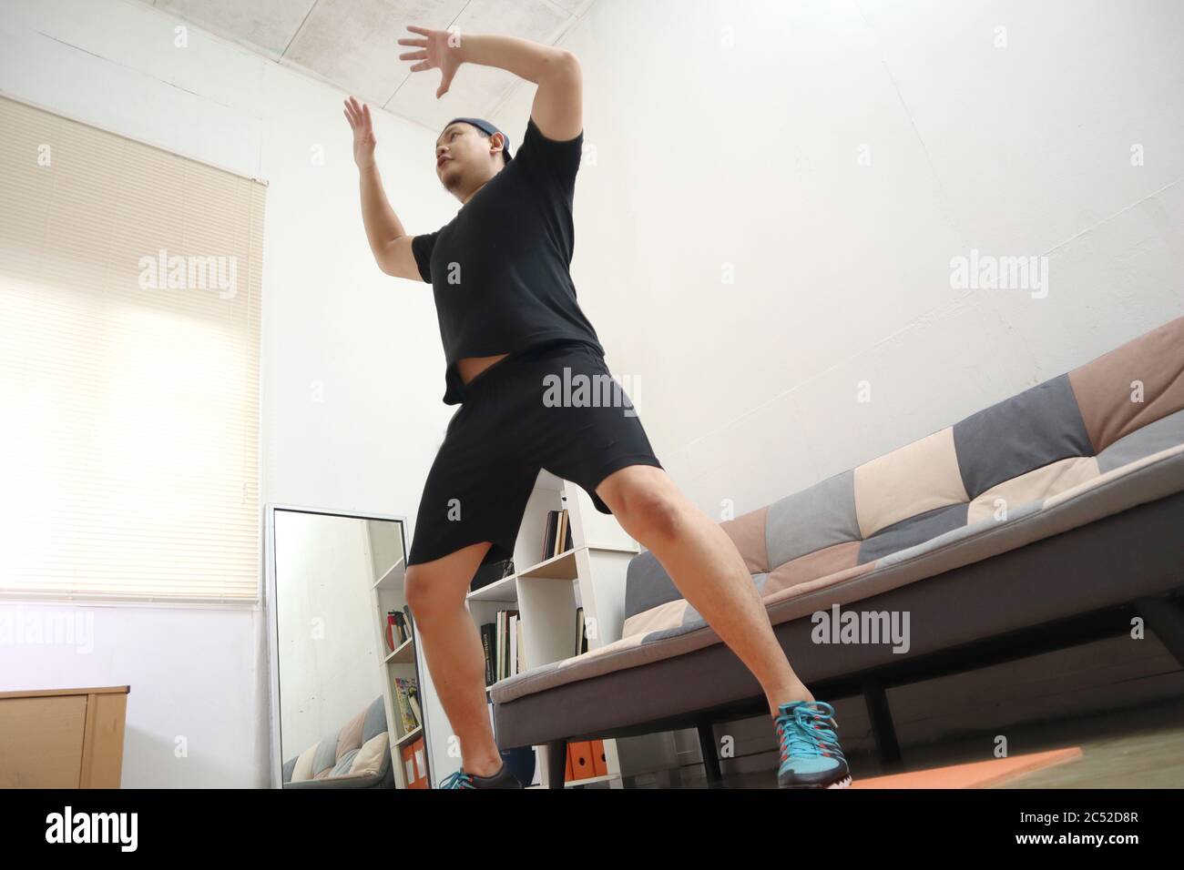 Asiatique homme faisant de l'exercice à la maison pour rester en bonne santé sur le nouveau mode de vie normal, intérieur à la maison concept d'entraînement, le poids du corps entraînement cardio circuit Banque D'Images