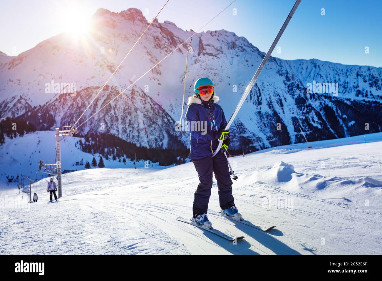 Bonne adolescente se levant sur la corde de ski de Drag Lift dans une tenue  de sport lumineuse et souriant avec la dernière lumière du coucher du  soleil Photo Stock - Alamy