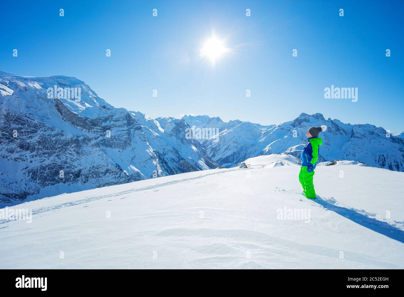 Garçon en cours de randonnée marcher sur la neige vierge sur le sommet de montagne hiver activité concept portrait pleine hauteur avec espace de copie panoramique Banque D'Images