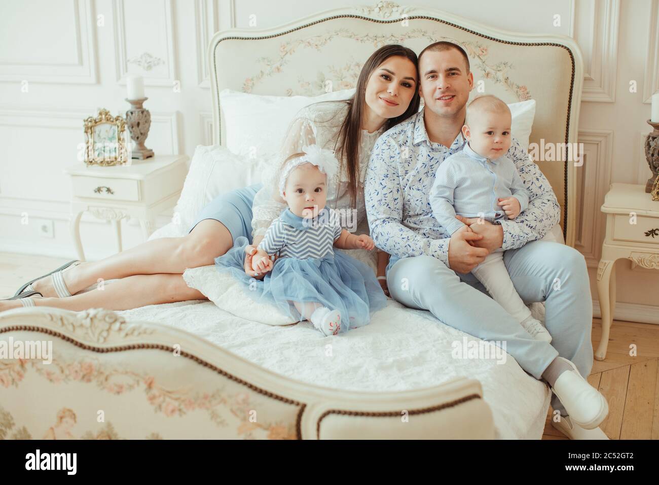 Portrait d'une famille assise sur un lit Banque D'Images