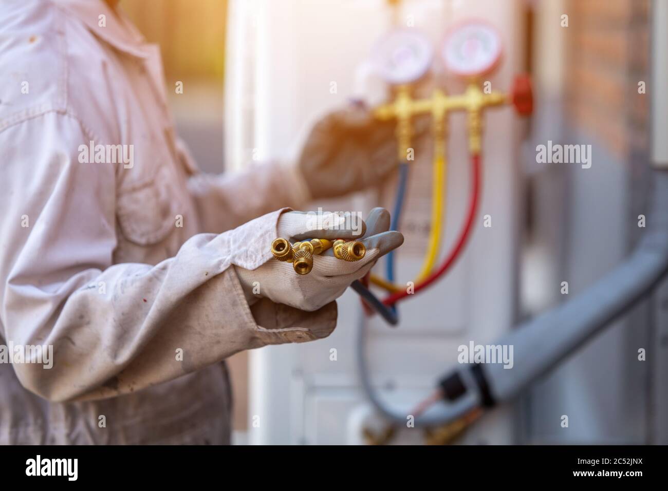 Technicien vérifiant une jauge de liquide de climatisation, Thaïlande Banque D'Images