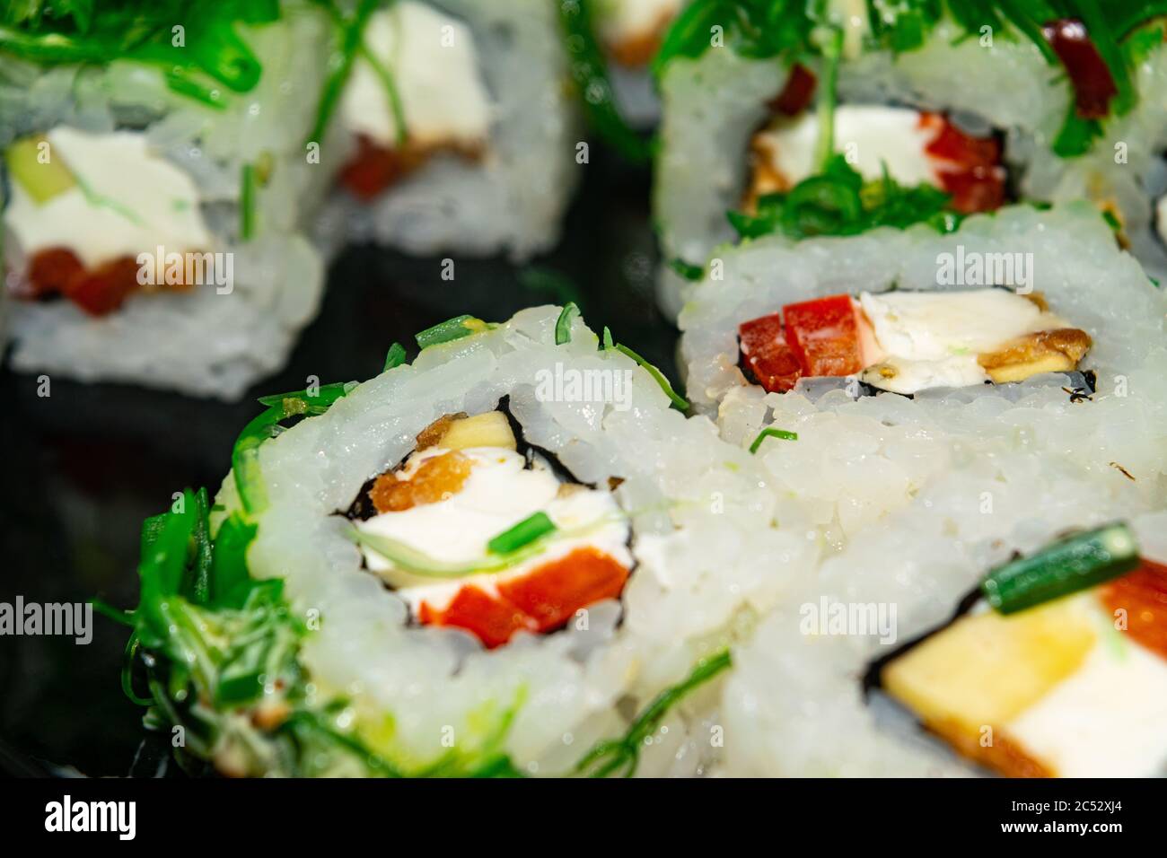 Petits pains avec du poisson, du fromage et des algues vertes. Un plat traditionnel japonais. Gros plan Banque D'Images