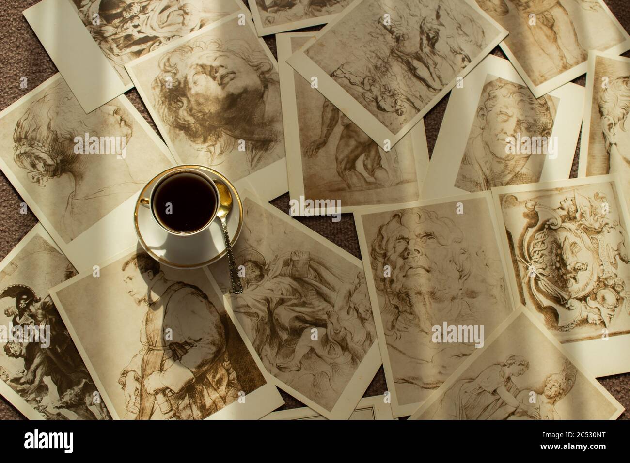 Les anciennes cartes postales sont dispersées de manière chaotique et une tasse se trouve sur elles Banque D'Images