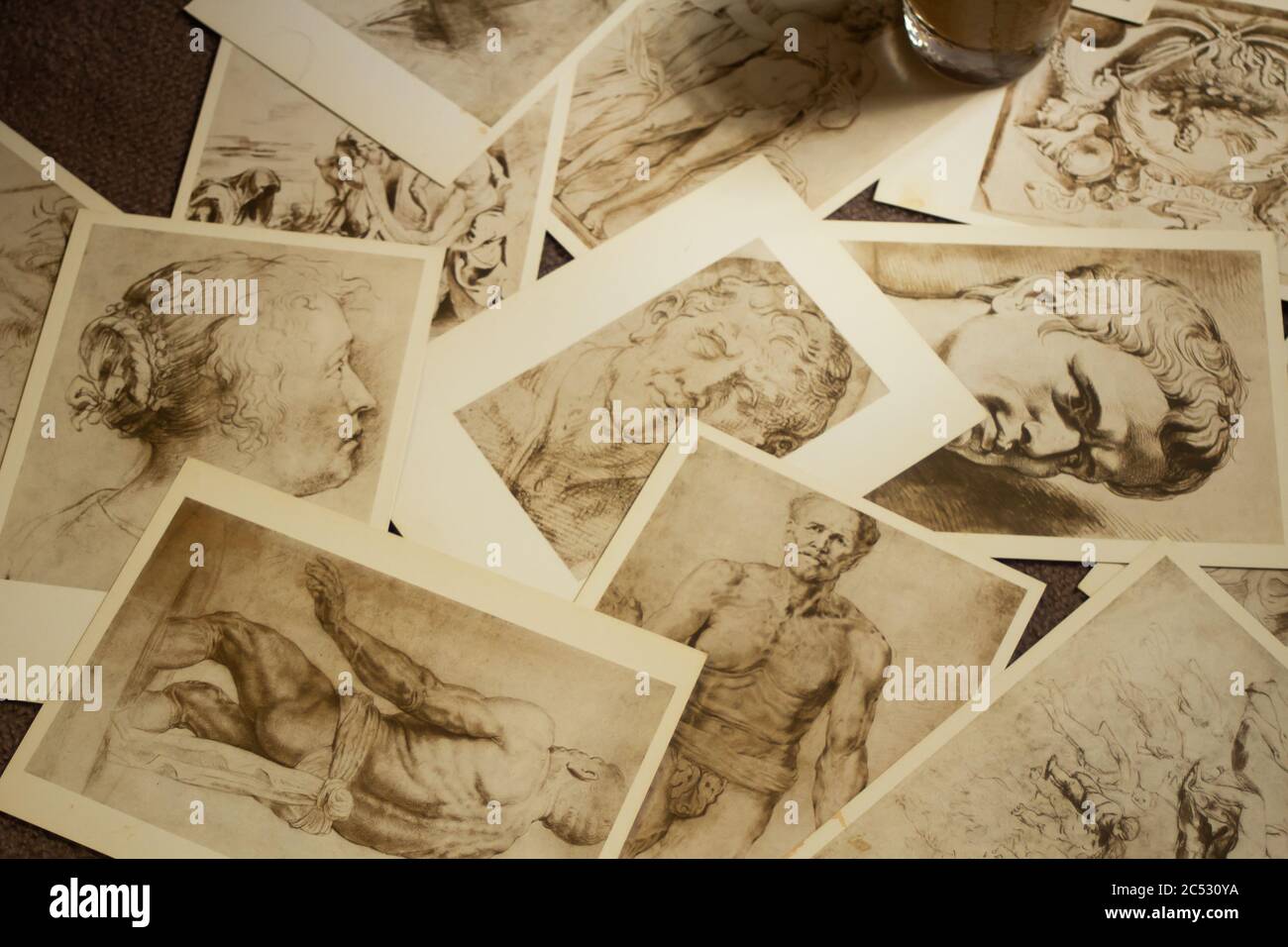 Les anciennes cartes postales sont dispersées de manière chaotique et une tasse se trouve sur elles Banque D'Images