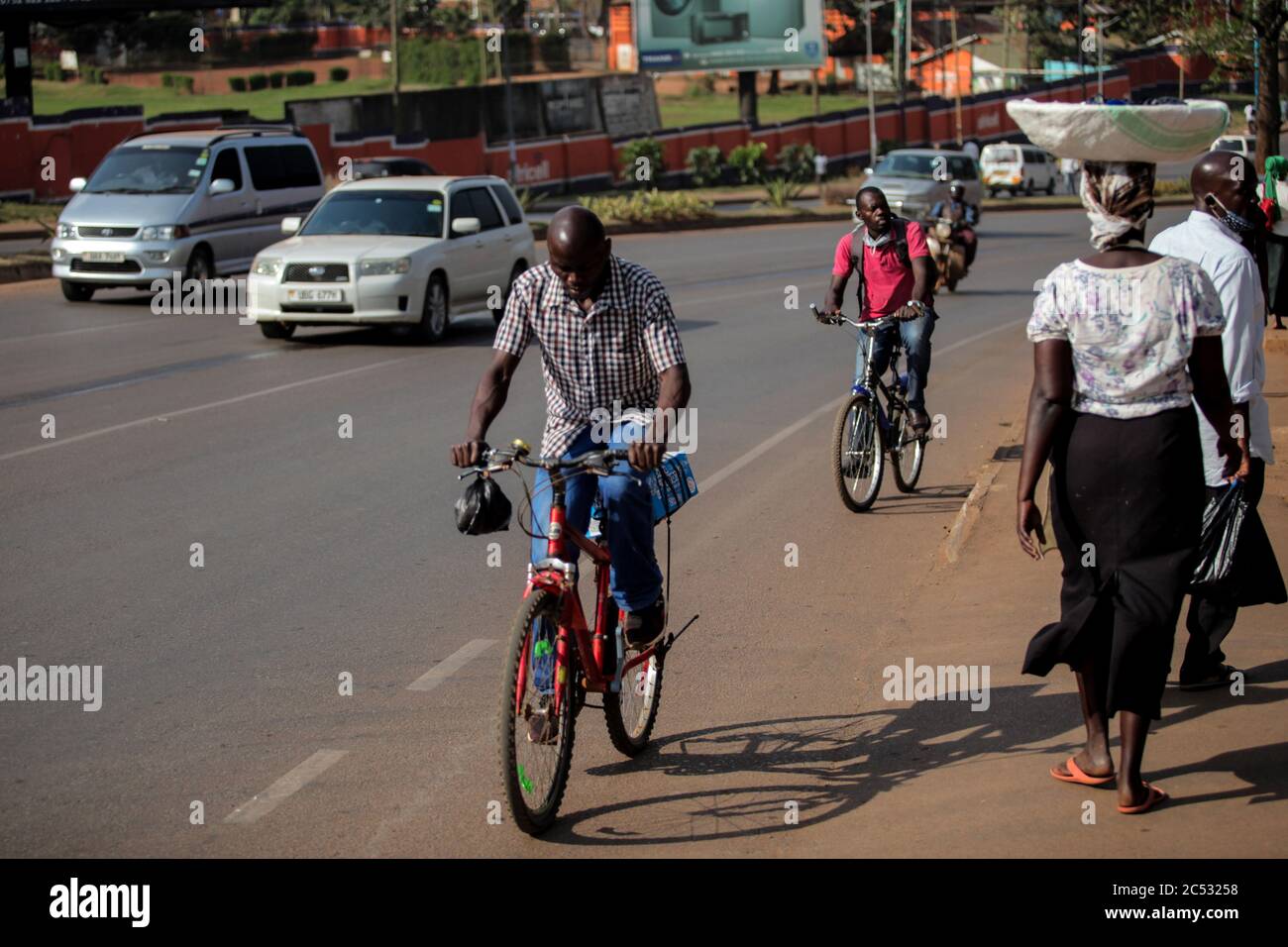 Kampala, Ouganda. 30 juin 2020. Les gens font du vélo le long d'une route à Kampala, capitale de l'Ouganda, le 30 juin 2020. Les gens ont eu recours au cyclisme comme moyen de transport favorable dans le contexte de la pandémie COVID-19 en Ouganda. Crédit: Hajarah Nalwadda/Xinhua/Alamy Live News Banque D'Images