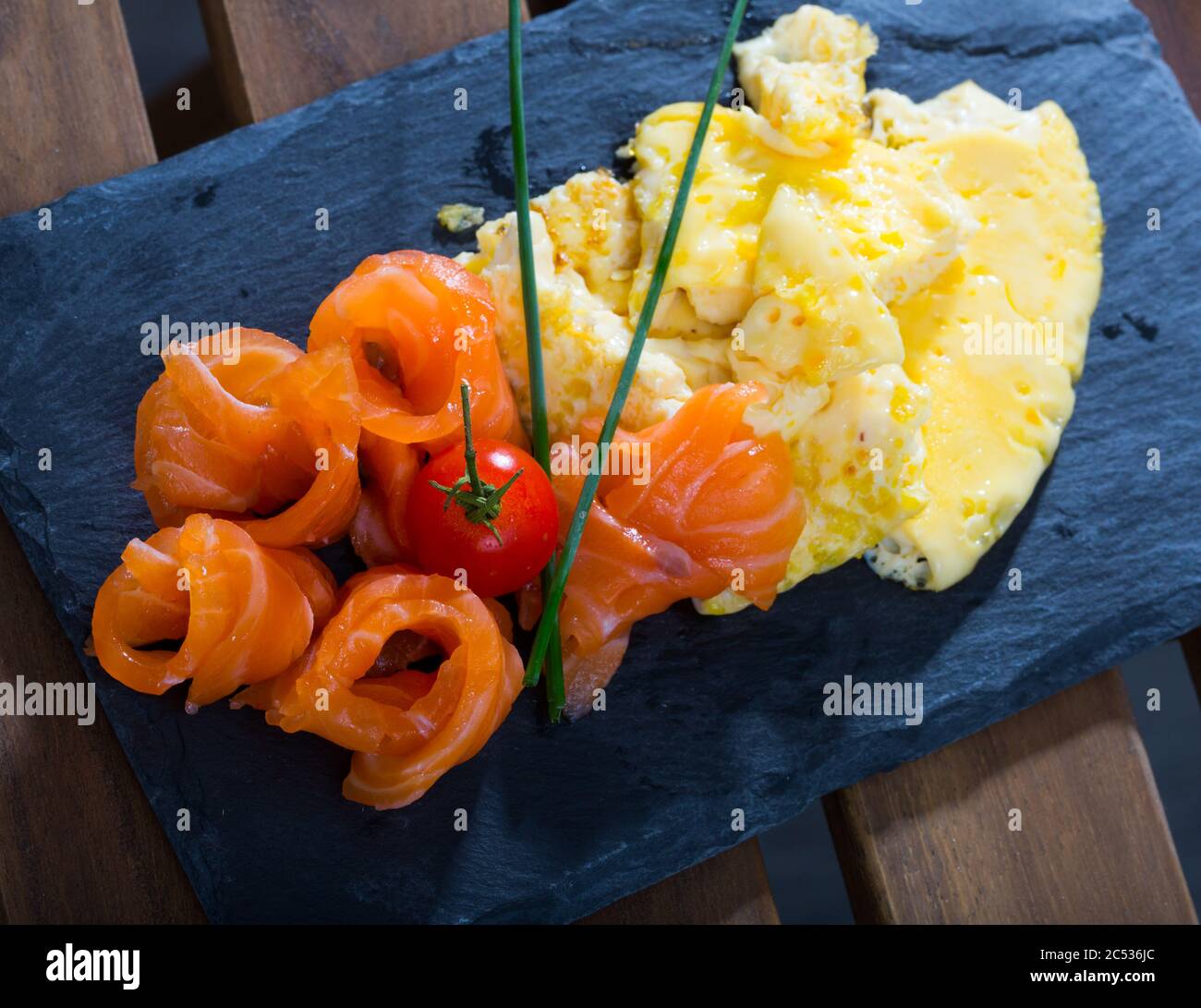Tasty omelette avec saumon fumé servi avec du persil sur tableau noir Banque D'Images