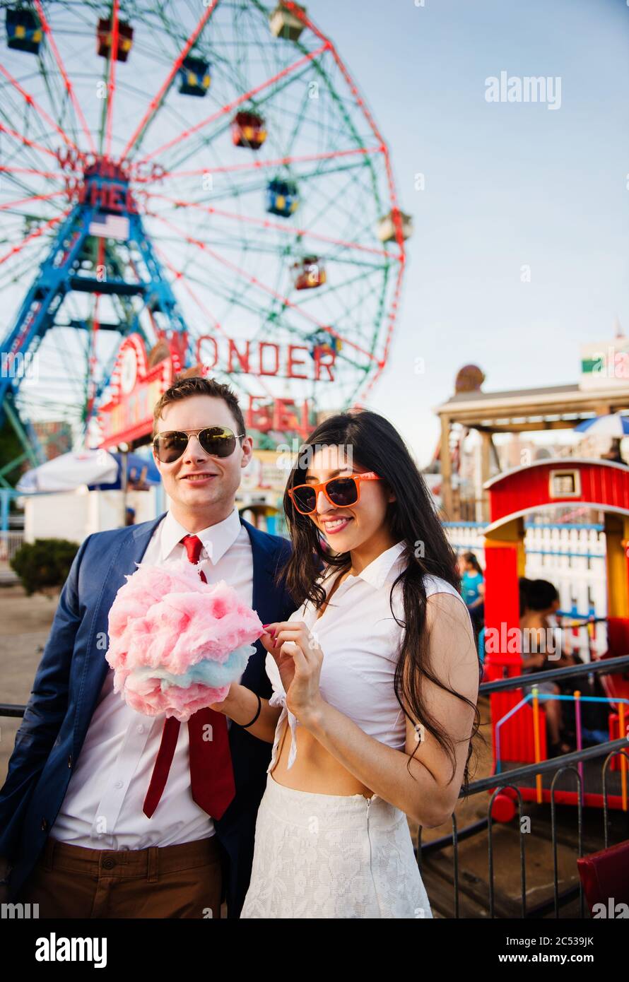 Jeune couple mangeant des bonbons en coton à Coney Island, Brooklyn, New York Banque D'Images