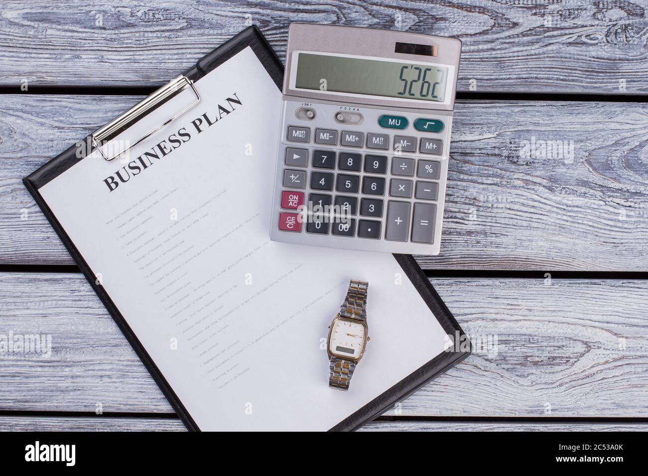 Presse-papiers avec plan d'affaires avec calculatrice et horloge de montre. Banque D'Images