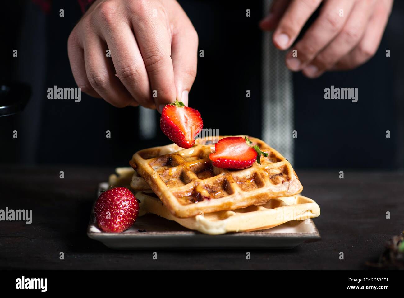 Ajouter les fraises sur un chef dessert gaufre close up Banque D'Images