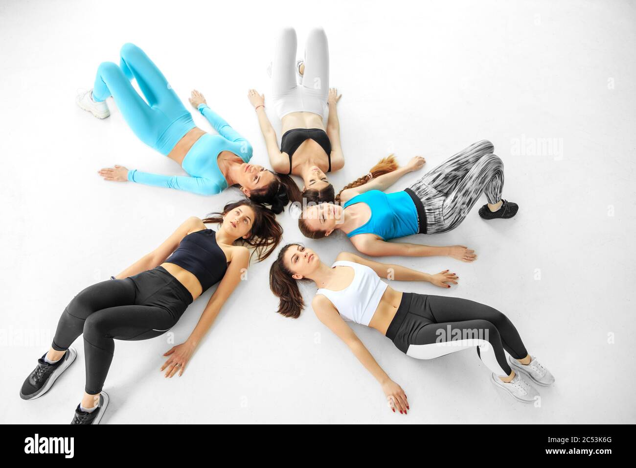 Une équipe de filles faisant du sport dans la salle de gym. Le concept de sport, de mode de vie sain, de forme physique, d'étirement. Banque D'Images