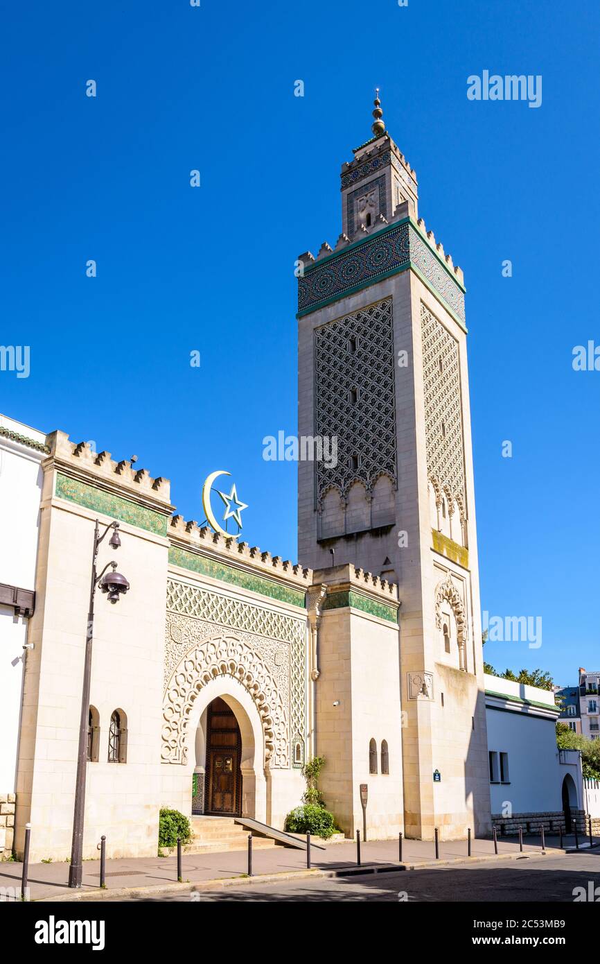 Entrée de la Grande Mosquée de Paris au pied du minaret de 33 mètres de haut, avec l'étoile et le croissant au-dessus de la porte contre le ciel bleu. Banque D'Images