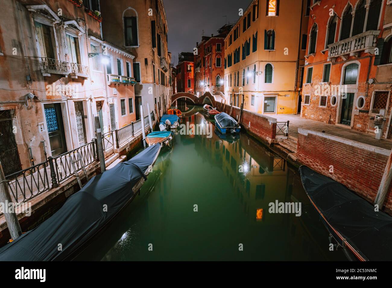 Venise Italie. Bateaux à canal étroit et à télécabine dans la ville lagon de venise la nuit. Vieux bâtiments en briques aux couleurs vives. Banque D'Images