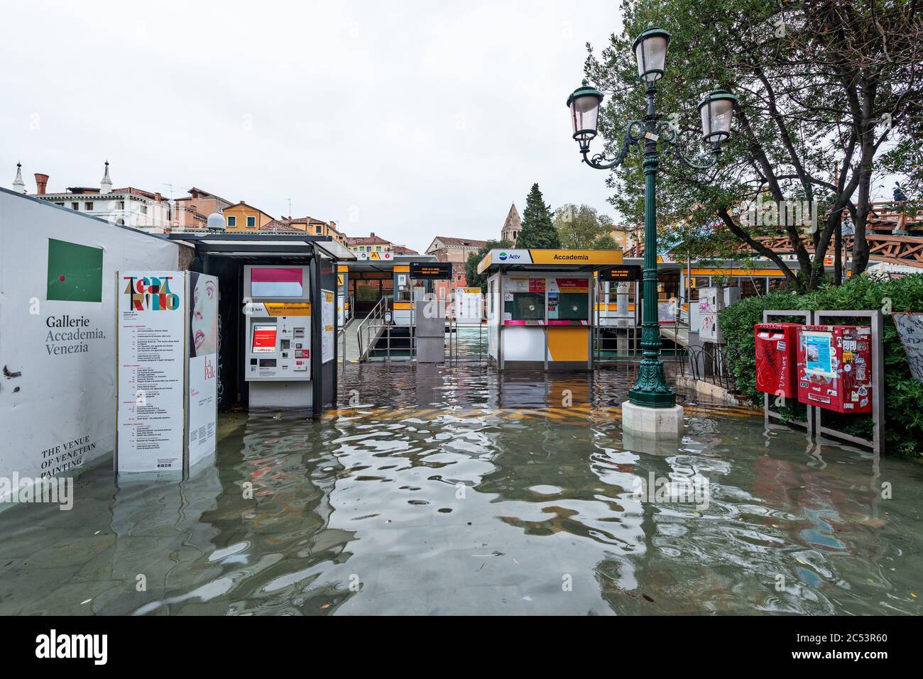 Arrêt de bus, bateau-bus, boîte aux lettres, machine à billets, arbres, clôture, inondation, eau, Aqua Alta, inondation Banque D'Images