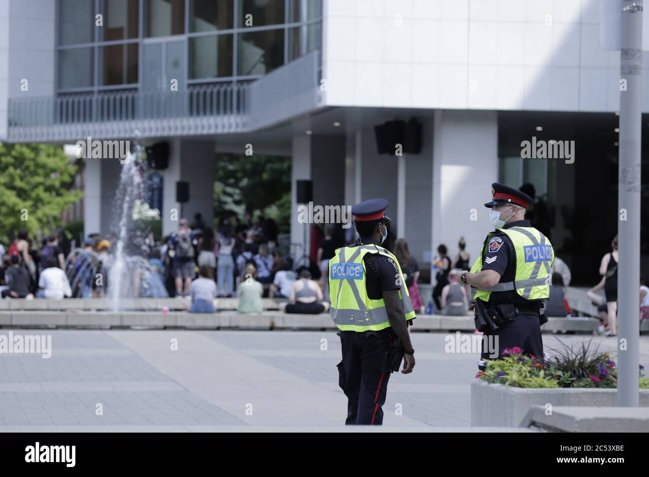 Deux policiers observent les gens qui se rassemblent pour une manifestation pacifique contre le racisme à l'hôtel de ville de Hamilton, Ontario Canada Banque D'Images