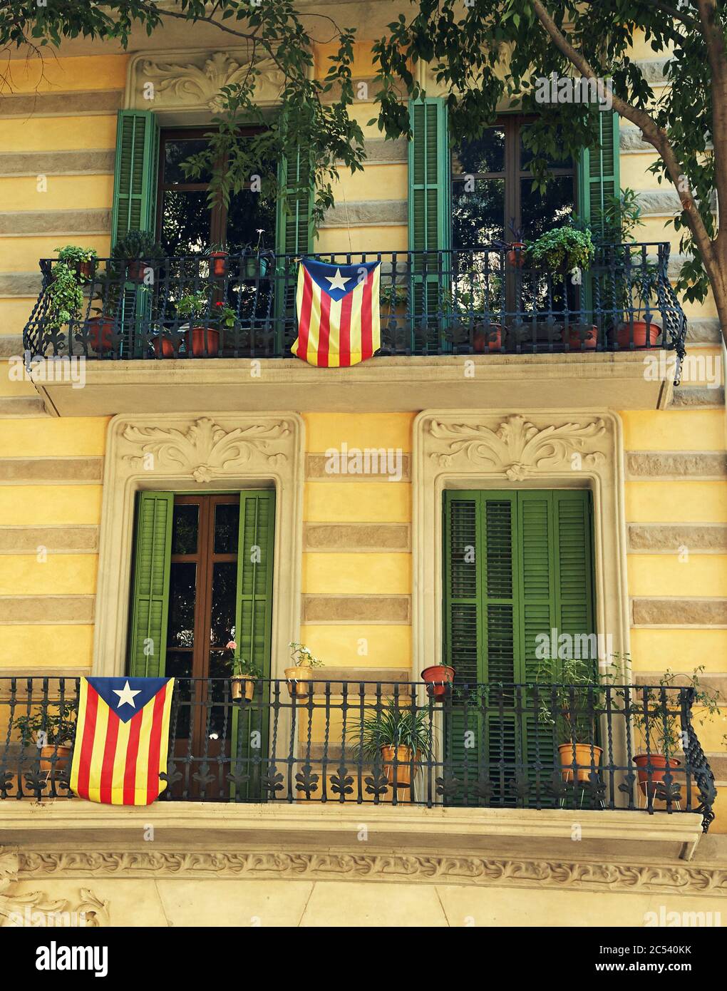 Drapeaux catalans accrochés sur les balcons d'un bâtiment à Barcelone. Banque D'Images