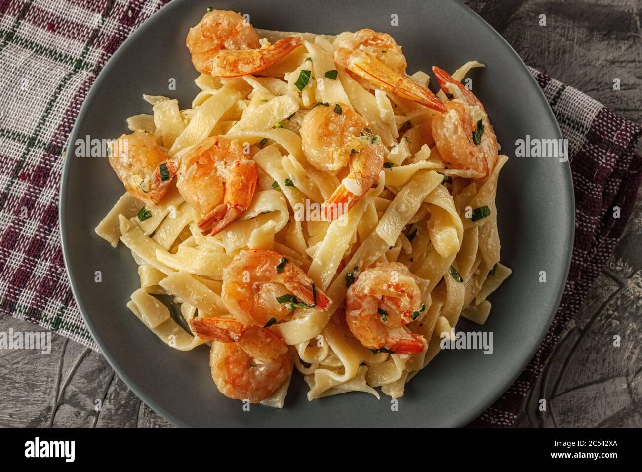 Tagliatelle aux crevettes et persil sur fond gris Banque D'Images