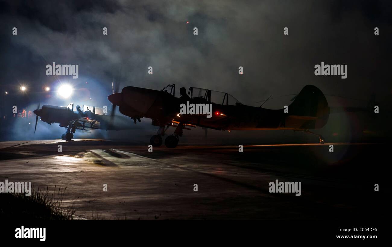 Petit avion aérobie aérobie monomoteur à piston unique parking après le coucher du soleil. Totalement sombre avec la foudre artificielle dans l'arrière-plan causant Banque D'Images