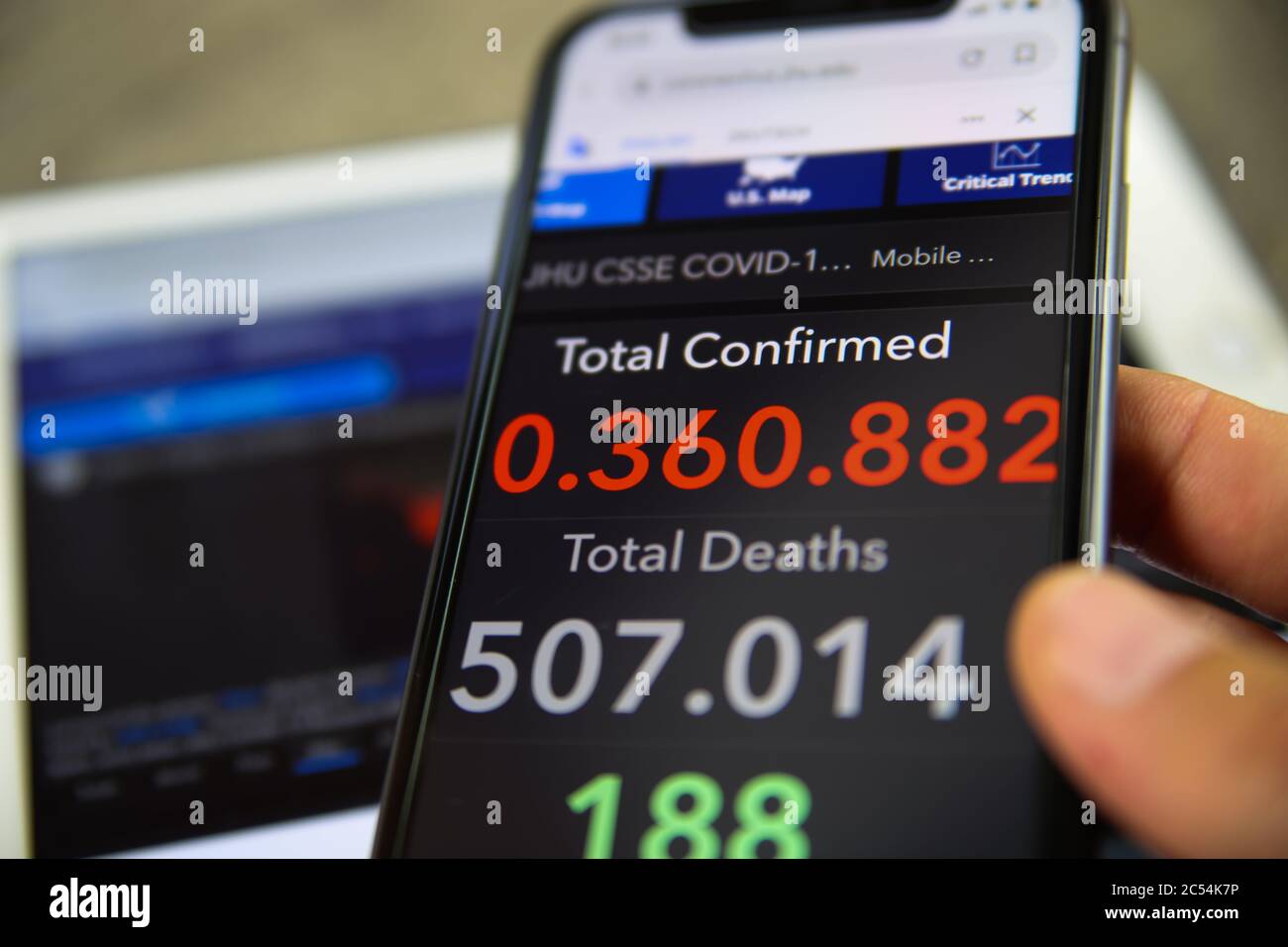 Viersen, Allemagne - juin 30. 2020: Gros plan de l'écran de téléphone portable tenir par main masculine avec le compteur de l'université John Hopkins montrant des nombres de worldwi Banque D'Images