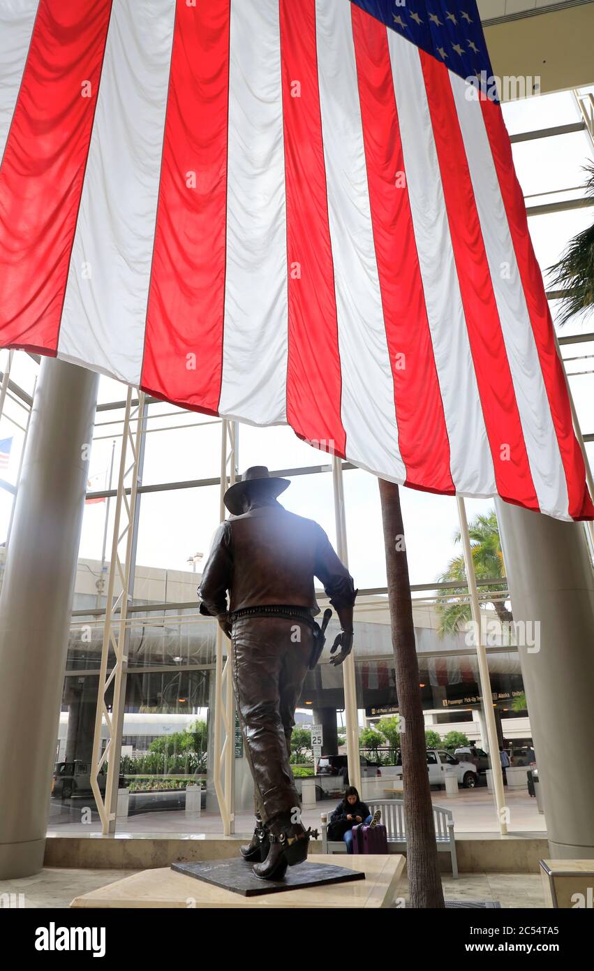 Une statue de John Wayne, grande et très célèbre, avec un drapeau américain de l'aéroport John Wayne. Santa Ana.Orange County.California.USA Banque D'Images