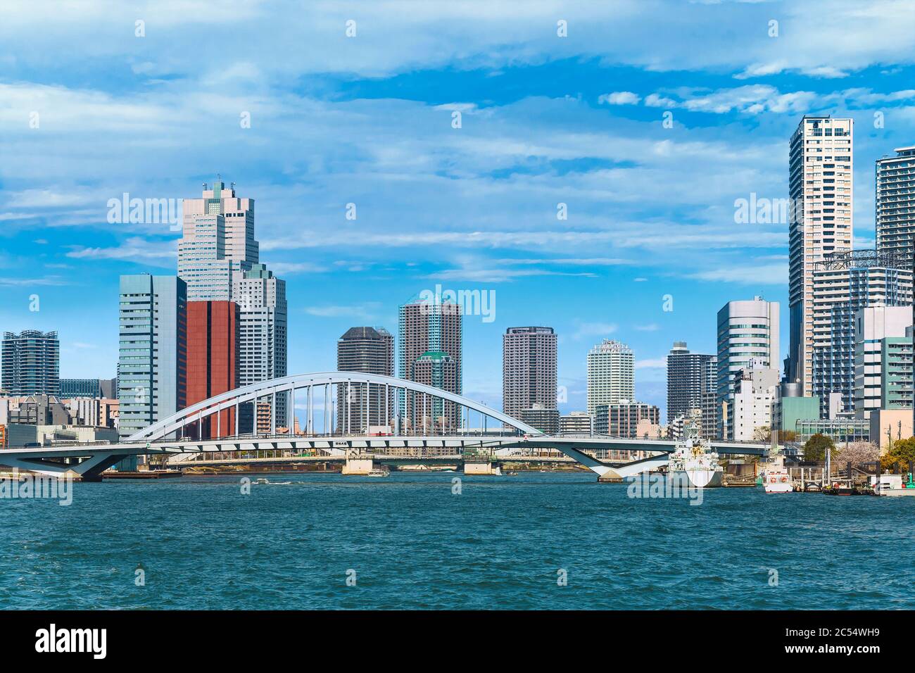 tokyo, japon - mars 15 2020: Pont d'arche de Tsukiji Ohashi sur le fleuve Sumida avec les bateaux amarrés de la baie de Tokyo et les gratte-ciels du Tsukiji Banque D'Images